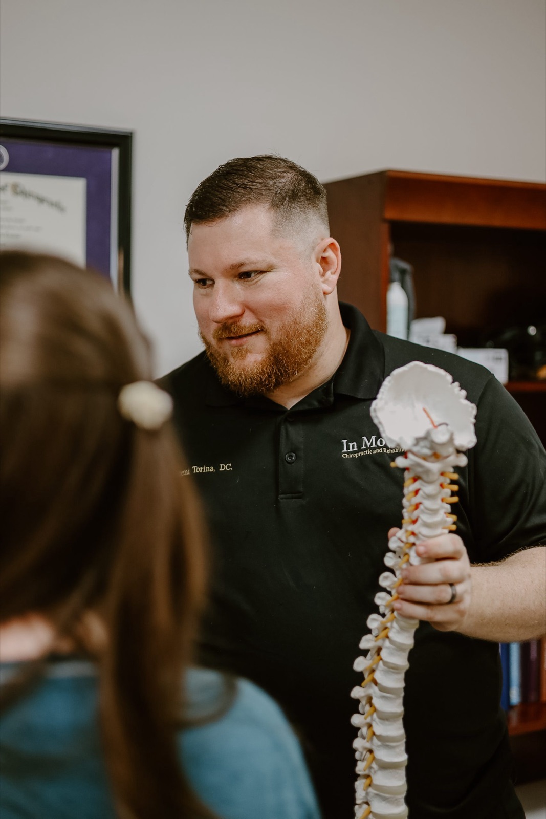Dr. Torina walking a patient through findings on a spine model