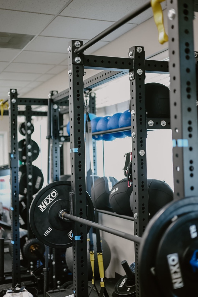 Racks, bars, and medicine balls on the training floor at In Motion in Oviedo